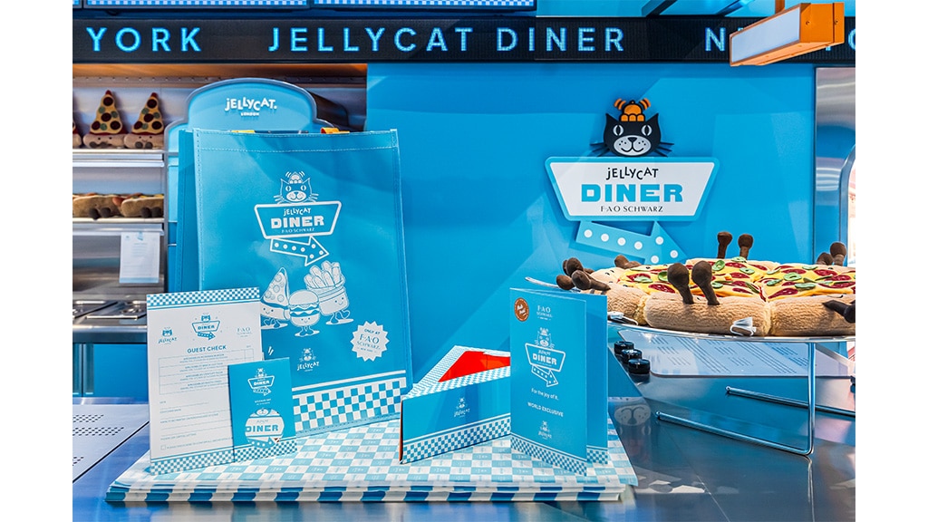 La figura de peluche frutal de Jellycat Diner se presenta con un menú