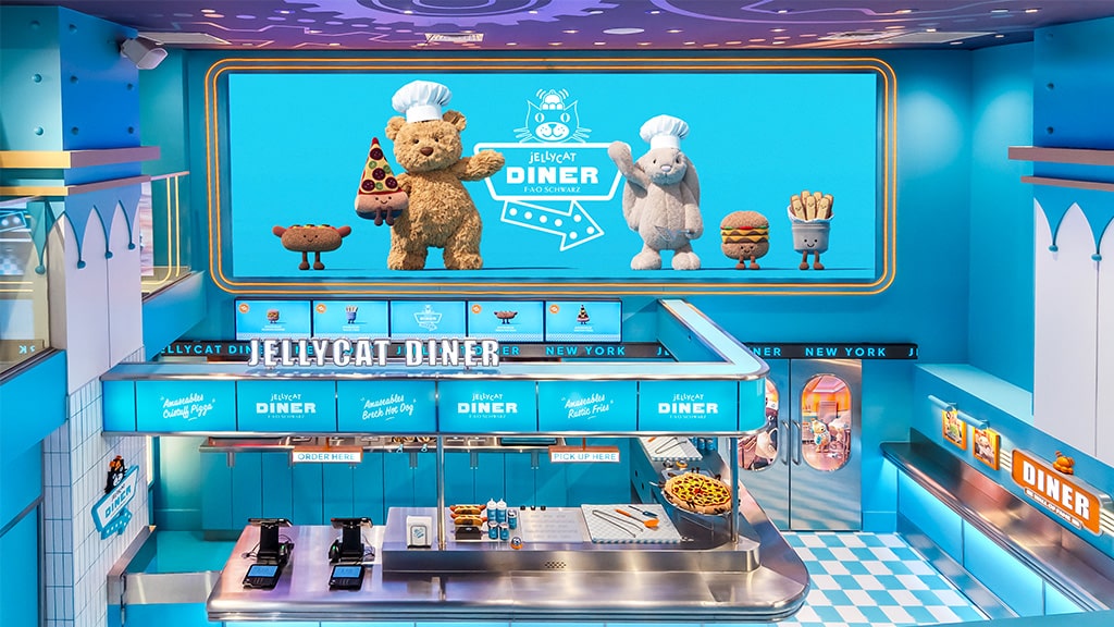 La figura de peluche frutal de Jellycat Diner se presenta con un menú